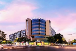Um hotel com vários andares e design moderno, com entrada e sinalização em destaque.
