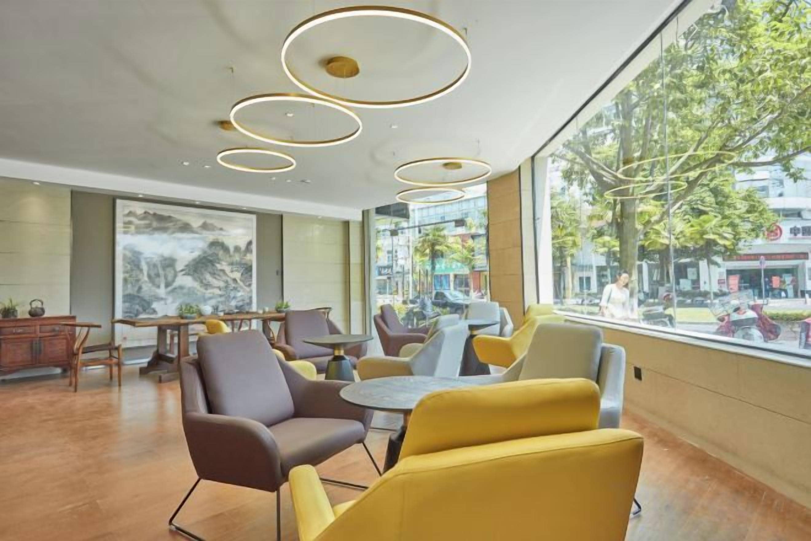 Un interior moderno con luces de techo redondas, asientos cómodos y amplias ventanas con vistas al exterior.