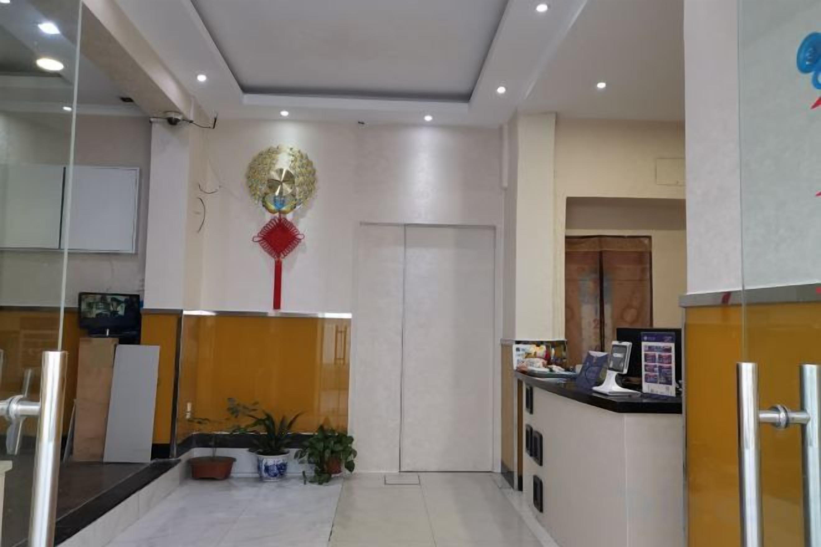 A reception area with a reception desk, a television, and a decorative wall hanging.