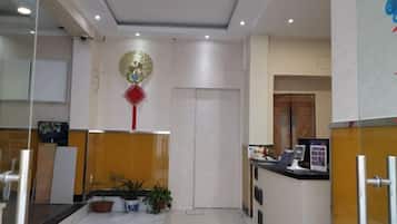 A reception area with a reception desk, a television, and a decorative wall hanging.