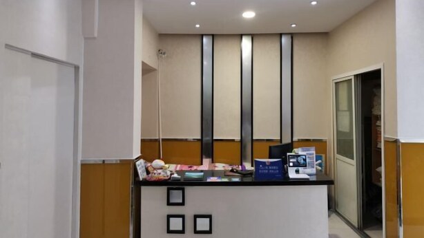 Un taulell de recepció amb un ordinador, fulletons i quadres emmarcats.