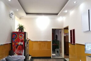 A hotel reception area with a reception desk, a plant, and a wall-mounted sign. - Gulou Holiday Inn (Hangzhou)