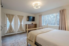 A bedroom with a bed, a dresser, a television, and a window with curtains. - Romeo & Juliet: 2 Living Areas/Kitchens! (Grand Junction)
