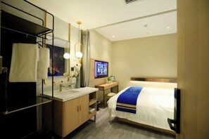A hotel room with a bed, a desk with a computer, a TV, and a bathroom with a mirror and sink. - Super 8 Plus Hotel (Beijing Tiananmen Square Qianmen Pedestrian Street) (Beijing)