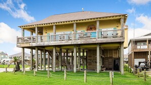 A two-story wooden building with a balcony, a sign reading "Barbecue," and a chain-link fence in front.