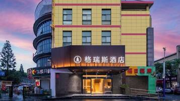 Un hotel con fachada moderna, varios pisos y una entrada destacada.