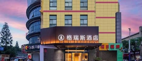 Um hotel com fachada moderna, vários andares e uma entrada imponente.