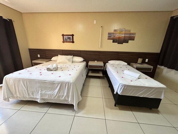 A hotel room with two beds, a nightstand, a wall-mounted clock, and a picture frame. - Pousada Bellíssima Itália (Luis Correia)