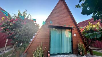 A wooden triangular structure with a door and a number '15' sign.