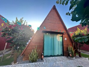 Una estructura de madera triangular con una puerta y un letrero con el número 15.