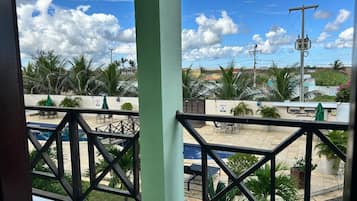 Vista de un área de piscina en la azotea con mobiliario exterior y palmeras.