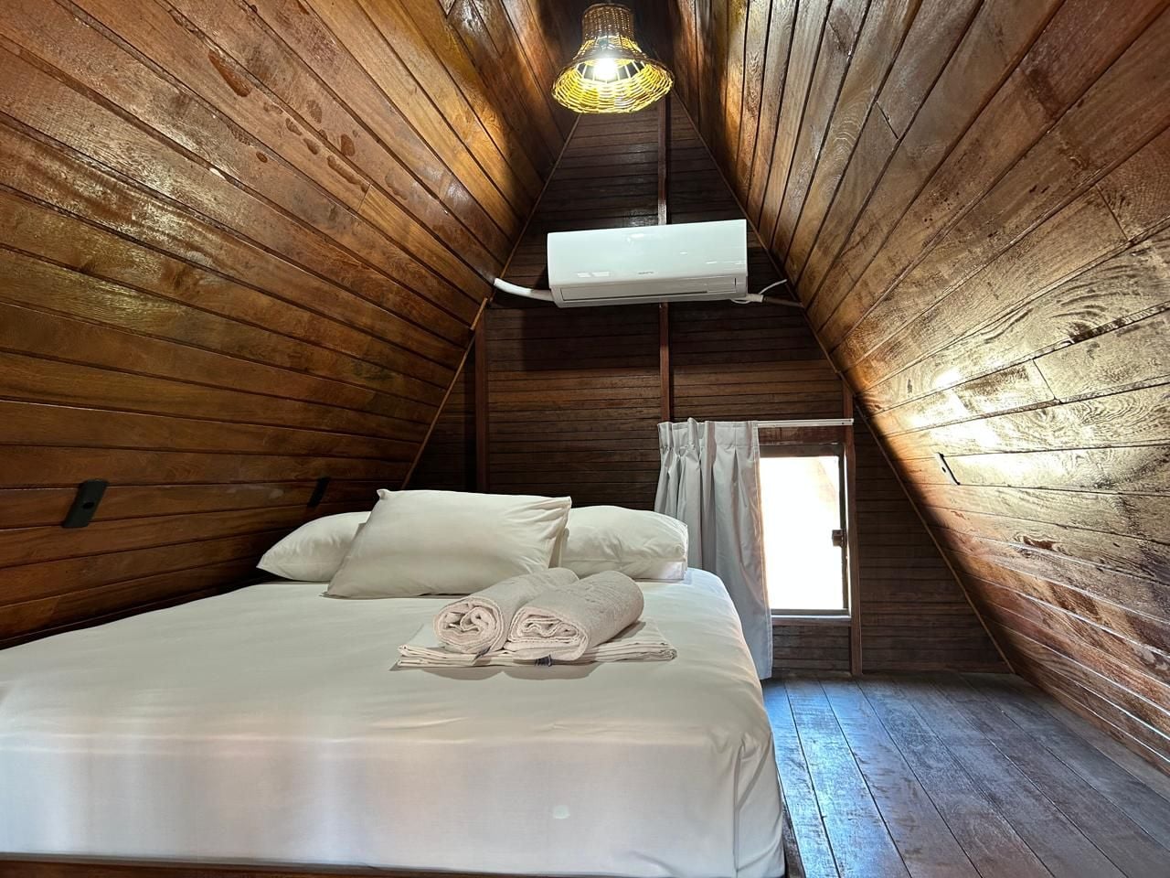 A room with a bed, a window, and an air conditioning unit.