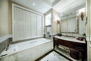 A bathroom with a large bathtub, a double vanity, and a large mirror. - Haizhou Hotel (Haining)