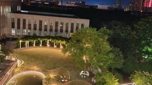 Un espacio al aire libre con piscina, mobiliario y un edificio al fondo.