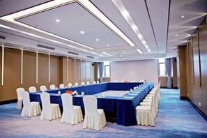 A conference room with a long table, white chairs, and a blue carpet. - Haizhou Hotel (Haining)