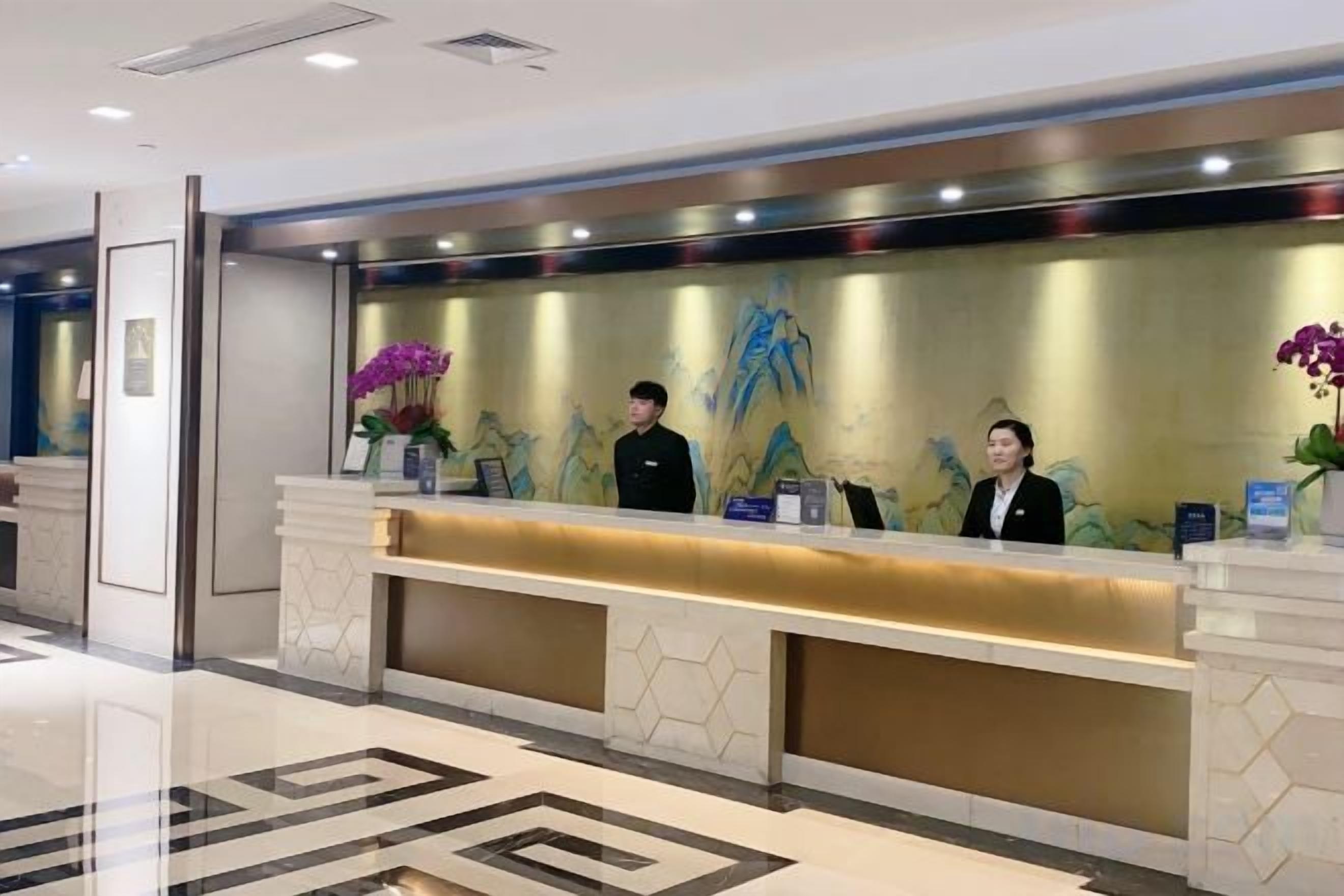 A reception desk with three staff members, a modern design, and a geometric floor pattern.