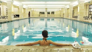 Una gran piscina cubierta con una persona relajándose en el borde.