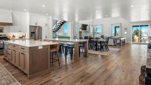 A spacious kitchen with a central island, wooden cabinets, and a stainless steel refrigerator. - Raspberry Retreat ~ Private Hot Tub ~ Indoor Pickleball (Garden City)