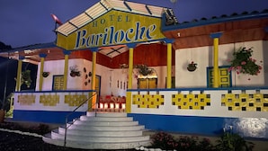 A colorful building with a sign reading "Hotel Bariloche." It features a staircase leading to the entrance, decorative plants, and a tiled facade. - FINCA HOTEL BARILOCHE (Santa Rosa de Cabal)
