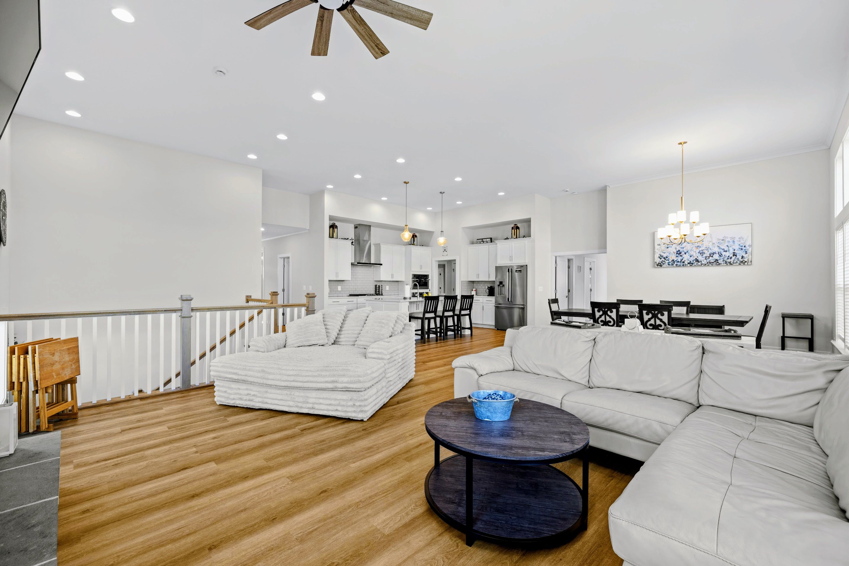A spacious living area with a sofa, a coffee table, and a dining table with chairs.