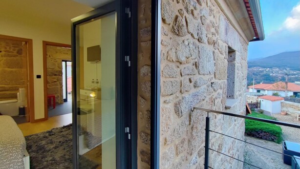 A balcony with stone walls and a view of the town. - Casa do Parada | Private Pool | Rural Refuge (Messegães Monção)