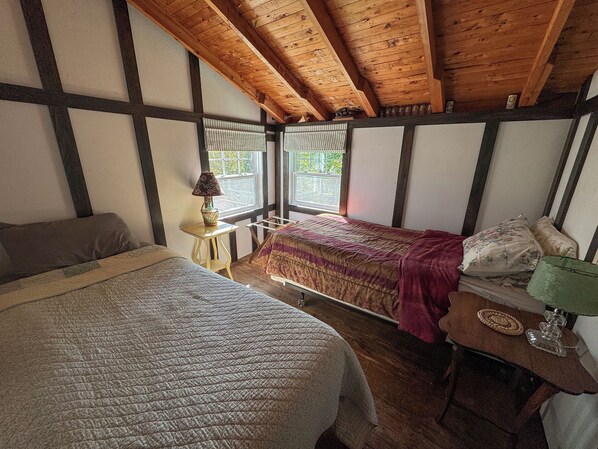Une chambre à coucher avec un lit, une table de chevet, une lampe et une fenêtre.
