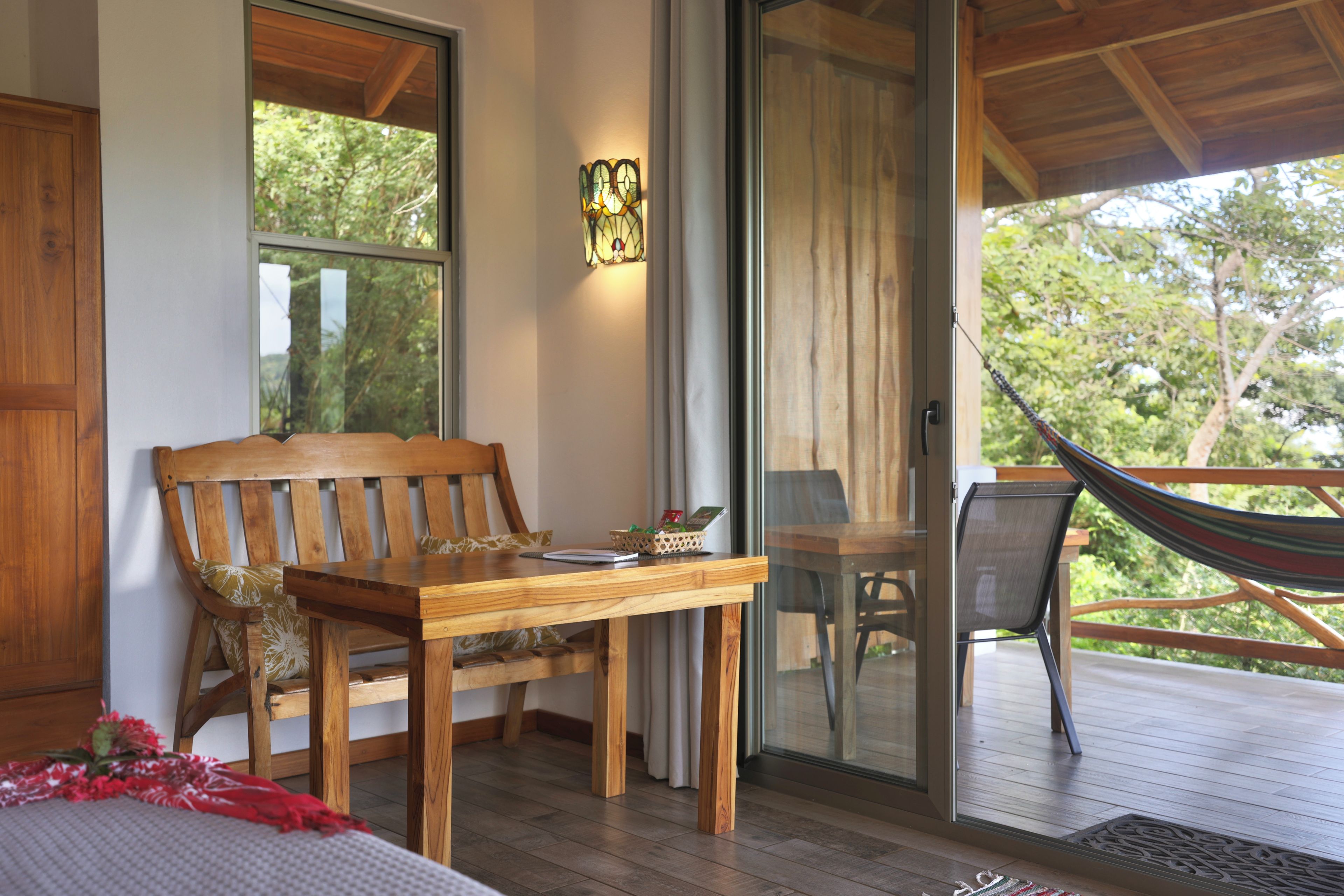 Cozy balcony with hammock, dining nook, and serene forest views