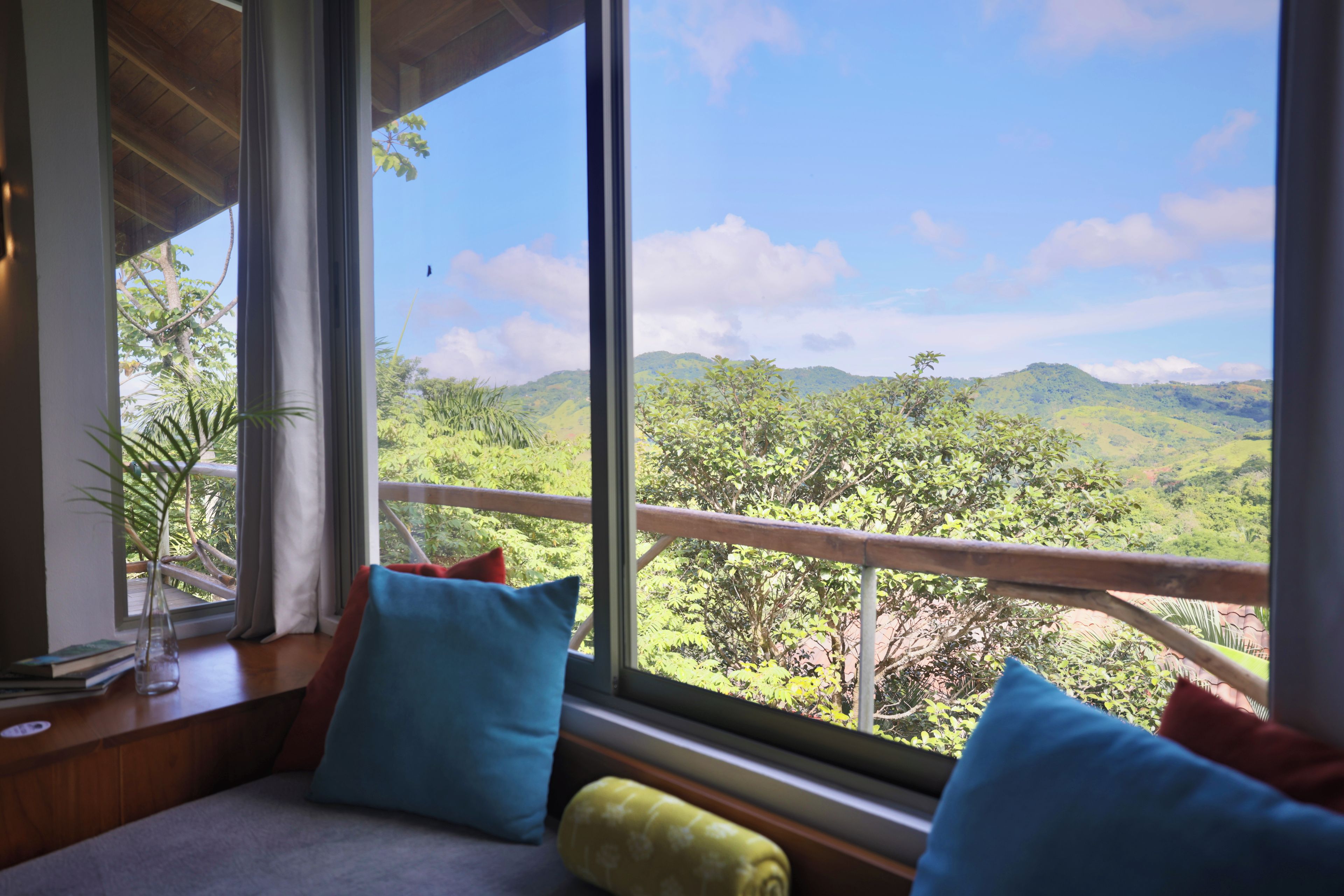 A room with a large window overlooking a mountainous landscape.
