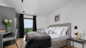 A modern bedroom with a large bed, a desk, and a view of the outdoors. - Villa Marichi – Countryside Retreat w/Pool & Sauna (Marići)