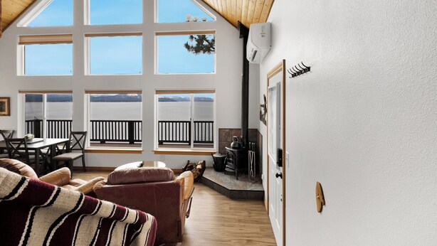 Una habitación acogedora con techo alto, ventanas amplias, chimenea y comedor.
