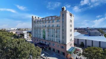 A multi-story hotel with a central courtyard, large windows, and a flat roof.