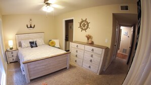 Ein Schlafzimmer mit Bett, Kommode und Stuhl.