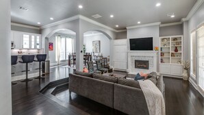 A spacious living room with a large sectional sofa, a fireplace, and a television.