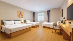A hotel room with a large bed, a smaller bed, a desk, and a chair.