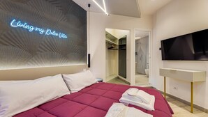 Une chambre d’hôtel moderne avec un grand lit, une télévision et un néon mural.
