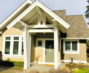 A house with a gabled roof, a front porch, and a small outdoor seating area.