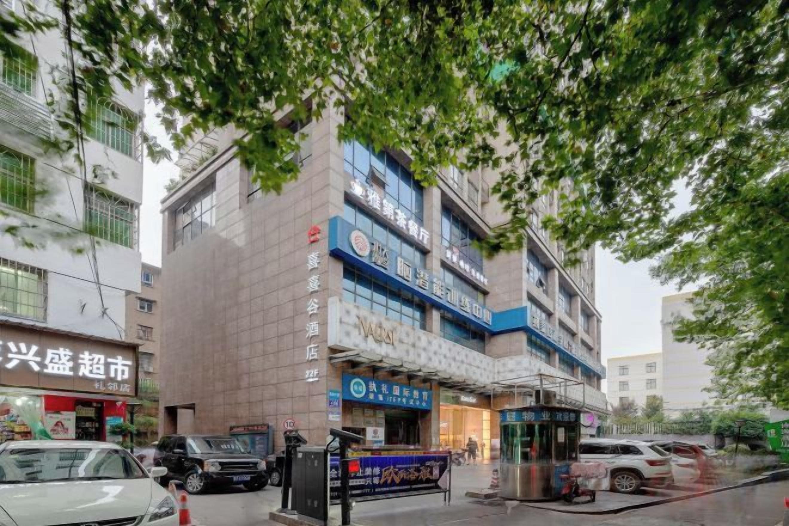 Een meerlaags gebouw met commerciële ruimtes op de begane grond, waaronder een restaurant en een apotheek.