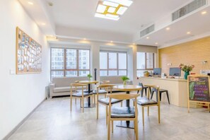 A modern hotel lobby with a reception desk, seating area, and large windows. - Changsha Xixigu Hotel (Provincial Children's Hospital Yali Middle School) (Changsha)