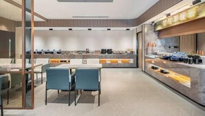 A modern hotel lobby with a central dining area, a reception desk, and a counter with amenities. - Starway Hotel (Beijing Beiyuan Lishuiqiao South Subway Station) (Beijing)