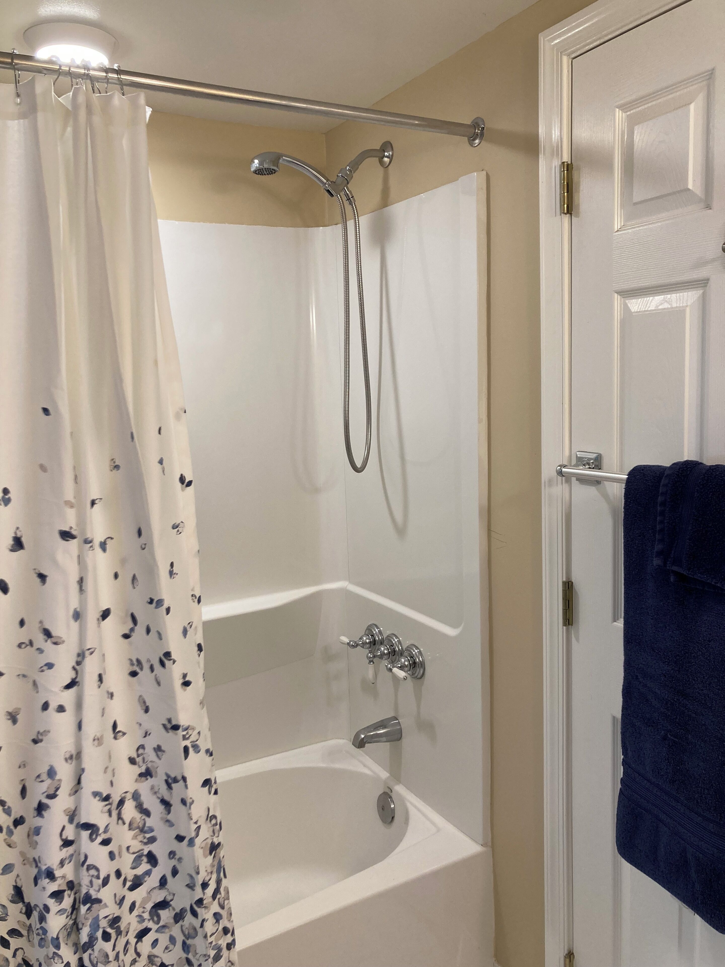 Un baño con ducha, bañera y puerta.