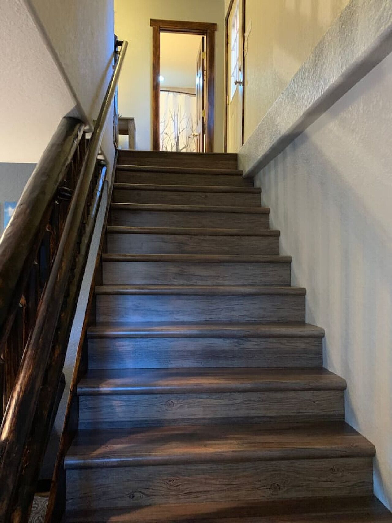 Una escalera de madera con barandilla que conduce a un espacio interior.