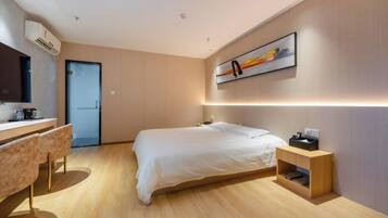 Quarto moderno com cama, mesa de cabeceira e escrivaninha com cadeiras.