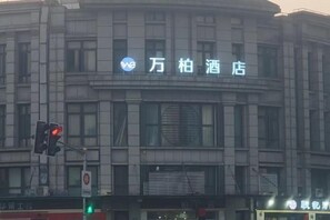 A building with a sign that reads '万柏酒店' indicating a hotel. - Wanbai Hotel (Shanghai Hongqiao Airport National Convention and Exhibition Center) (Shanghai)