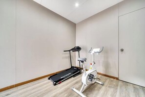 Una habitació amb una bicicleta estàtica, una cinta de córrer i una porta.