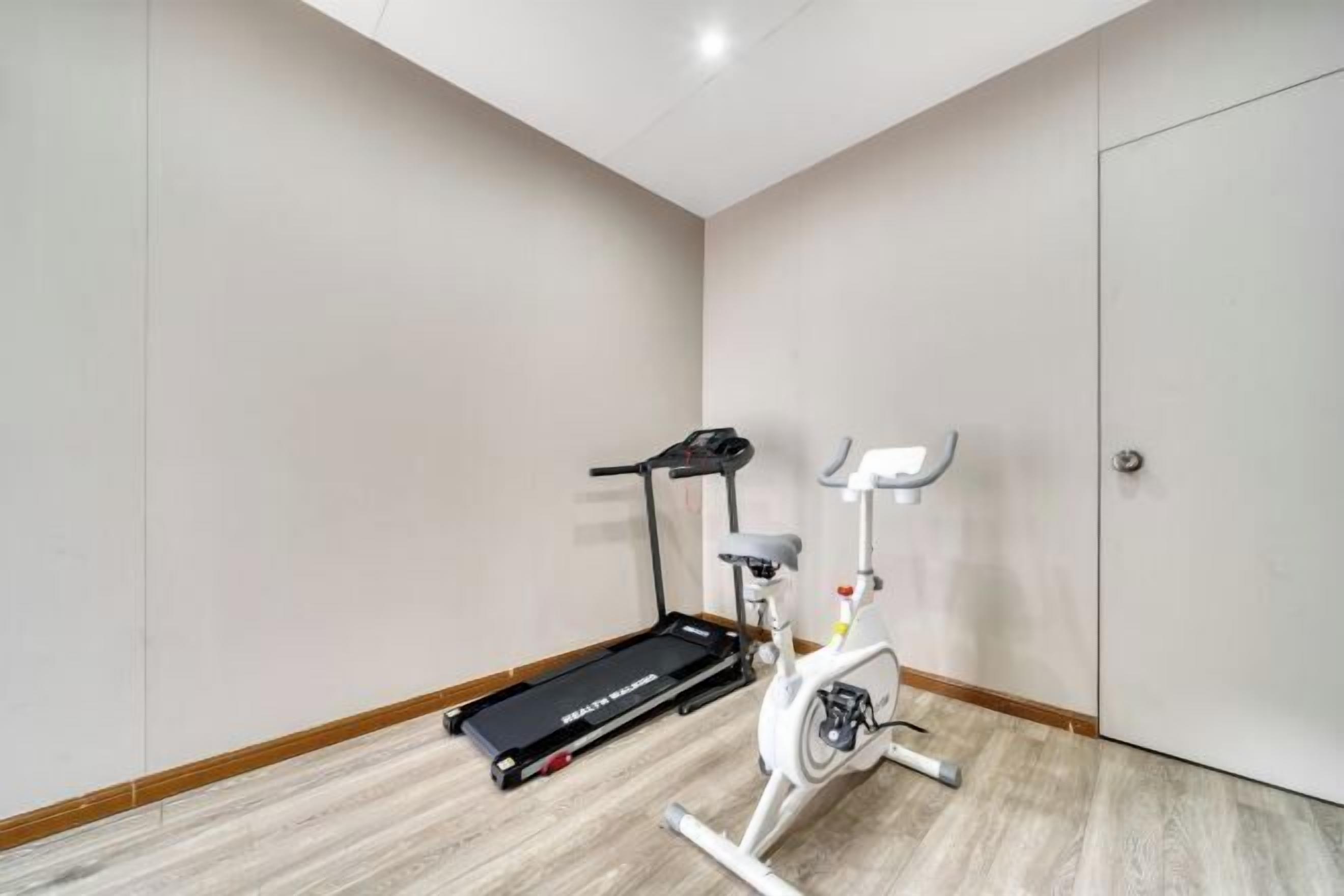 A room with a treadmill and an exercise bike.