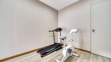 Quarto com esteira e bicicleta de exercício.