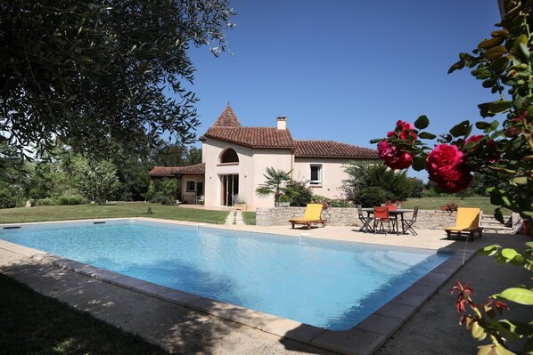 Une piscine avec une maison en arrière-plan.