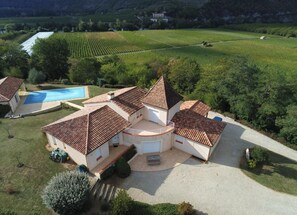 Une villa dotée d’une piscine, d’un court de tennis et bordée d’un vignoble.