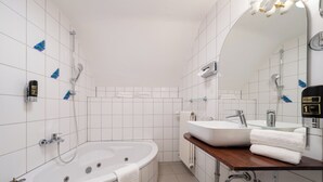 Ein modernes Badezimmer mit einer freistehenden Badewanne, einem Waschtisch und einem großen Spiegel.