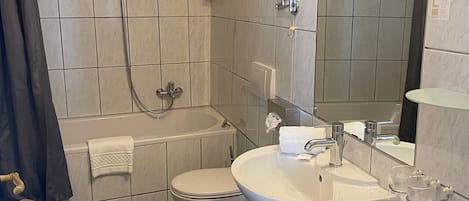 Ein Badezimmer mit einer Badewanne, Toilette und Waschbecken.